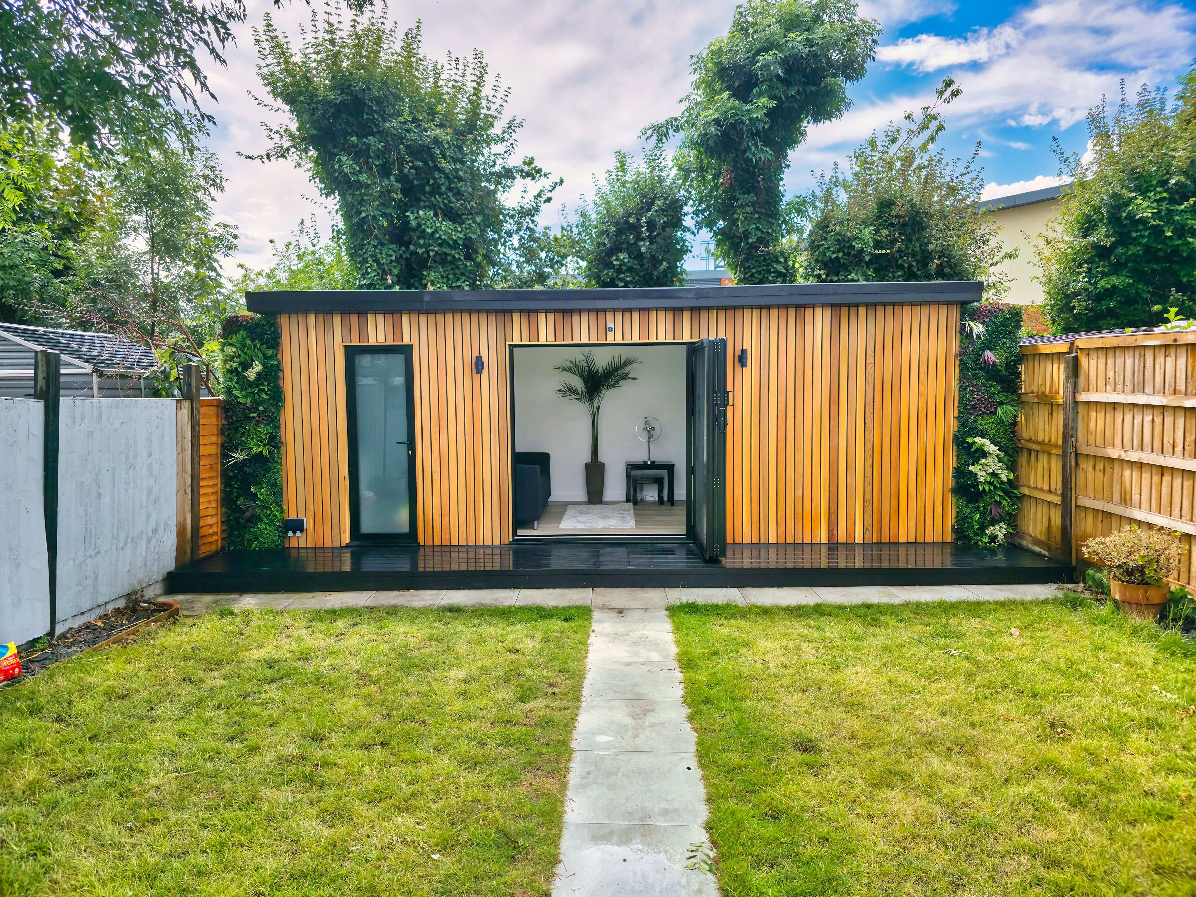 Cedar-clad garden room in Bedfordshire with bifold doors open onto a lounge