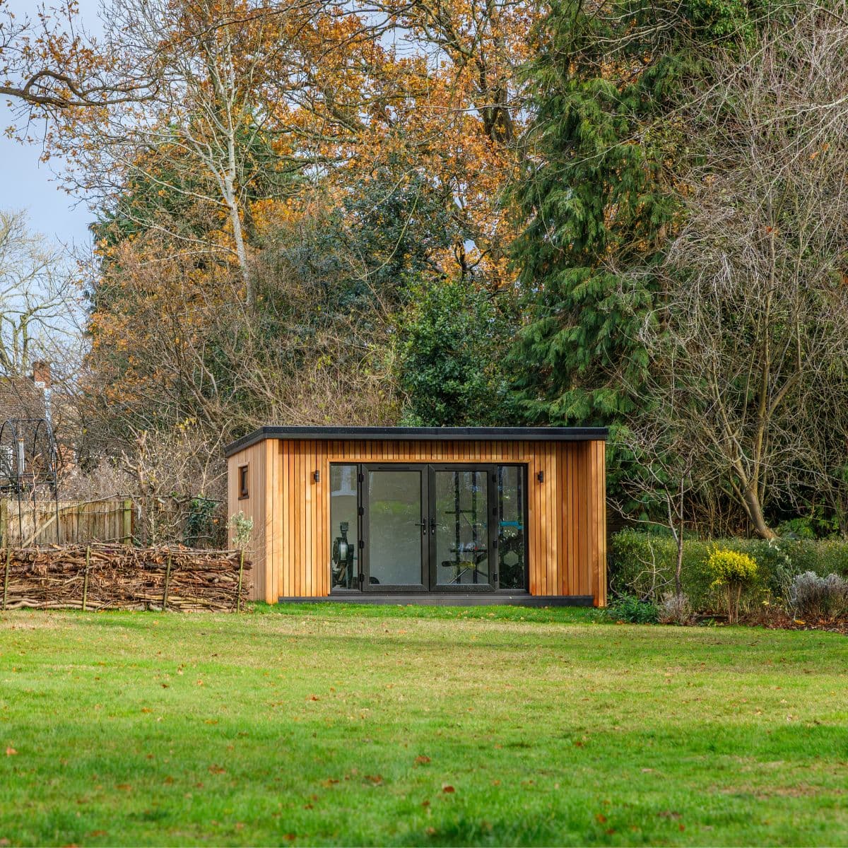 Insulated cedar-clad garden gym in a large Bedfordshire garden on an autumn afternoon