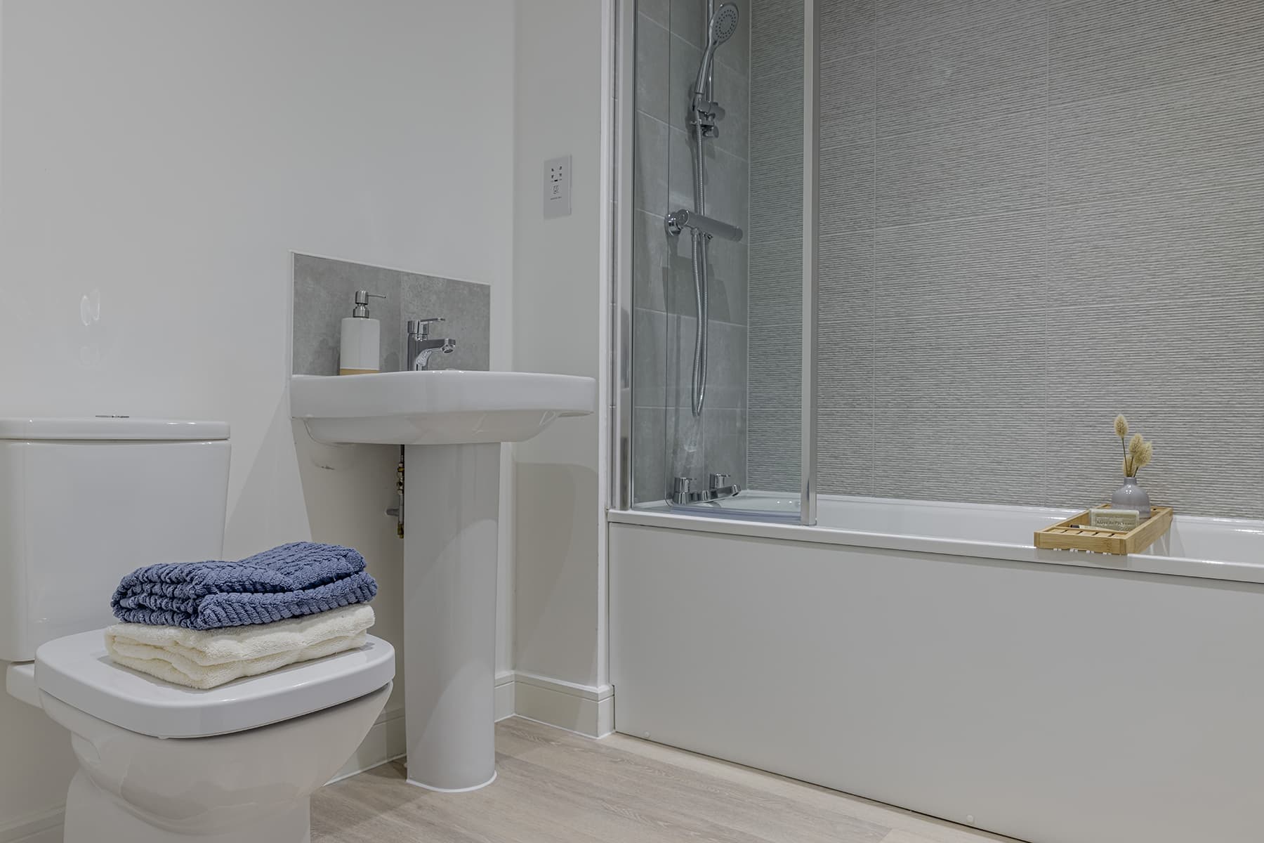 Garden annexe in Bedfordshire — annexe bathroom with a bath, shower over and a wall-hung basin