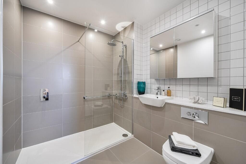 Garden annexe in Bedfordshire — walk-in shower room with a wall-hung basin and WC