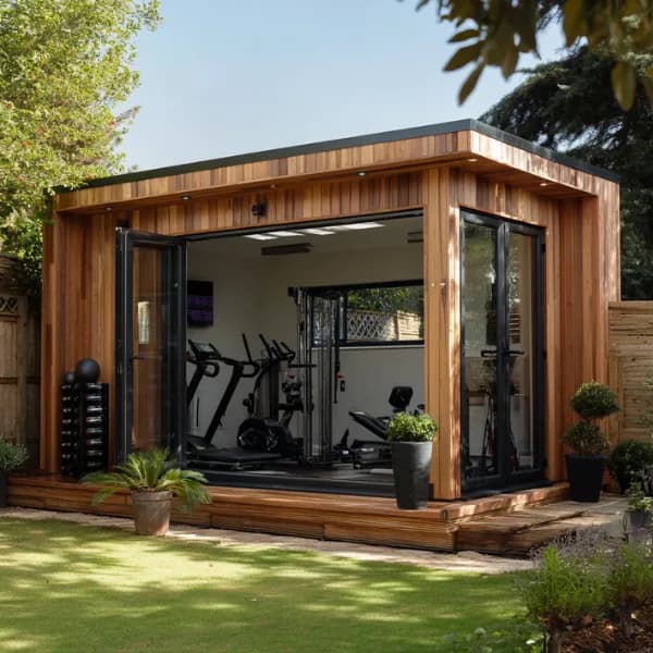 Timber-clad garden gym with open corner doors and exercise machines