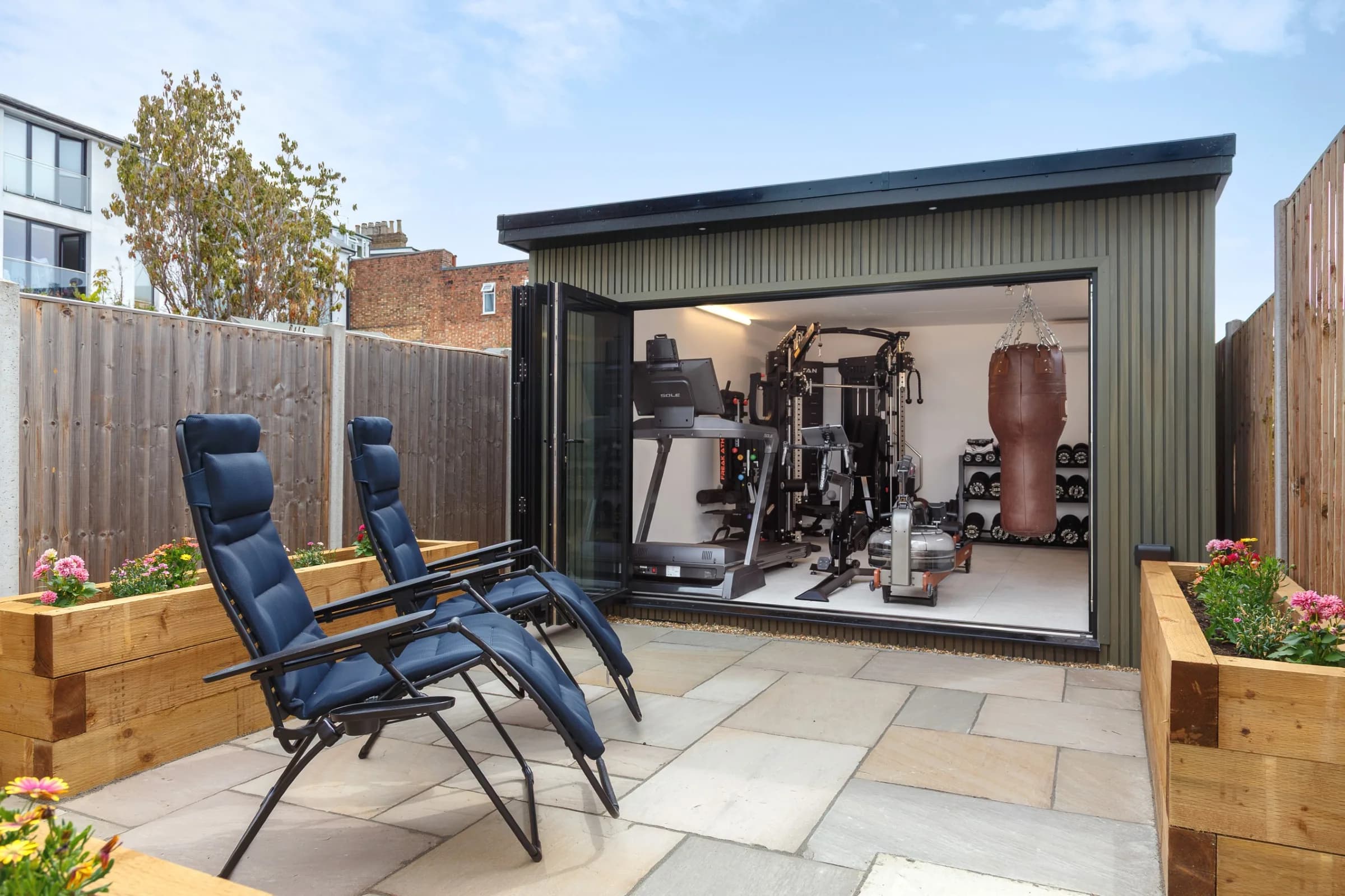 Open garden gym across a paved courtyard, with punch bag and exercise machines