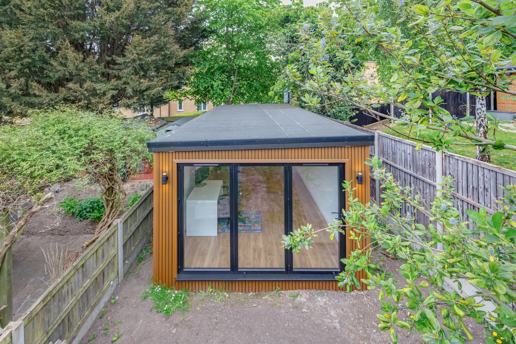 Elevated view of a timber-clad garden room with glazed doors