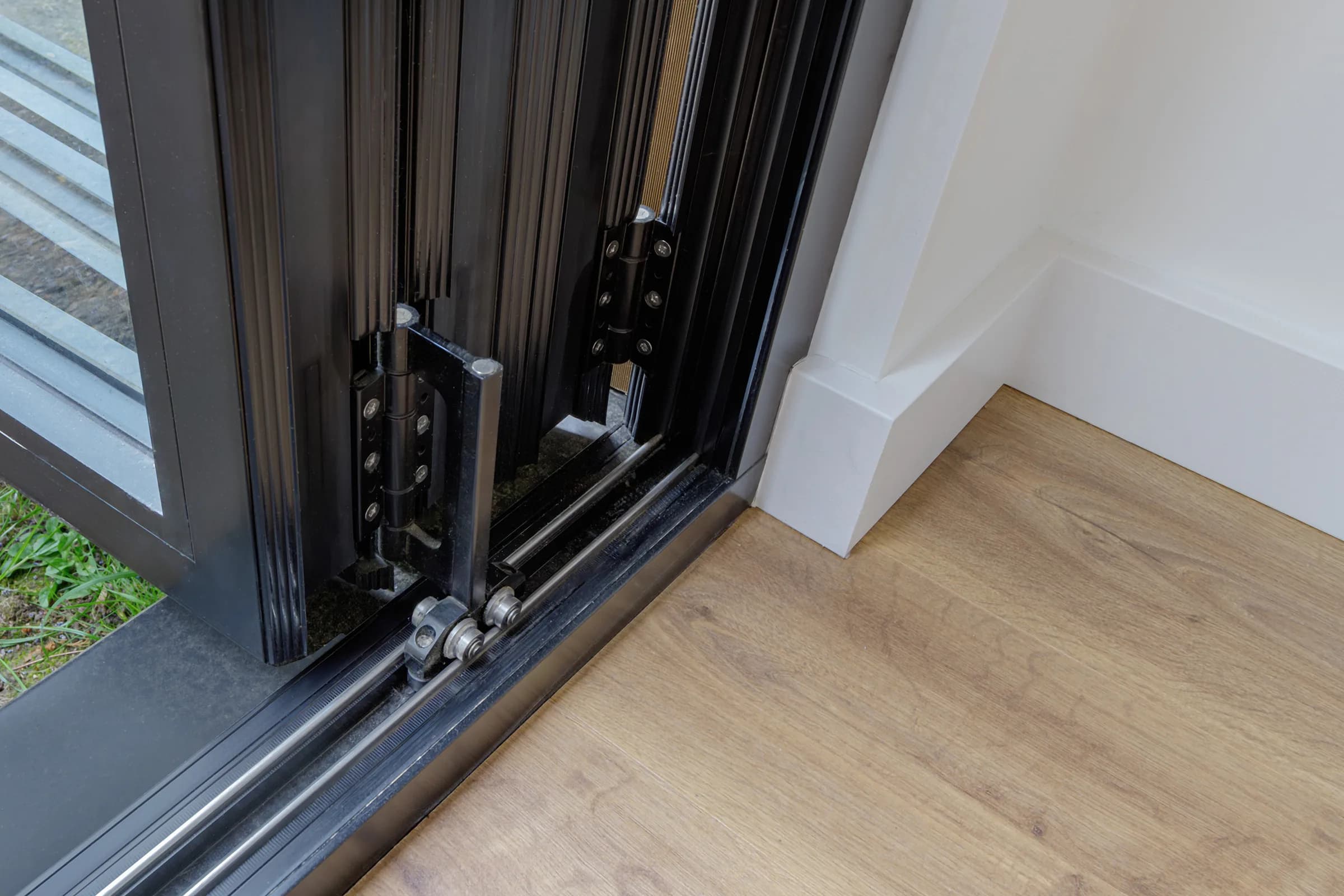 Close view of the folded glazed door track and threshold inside a garden room