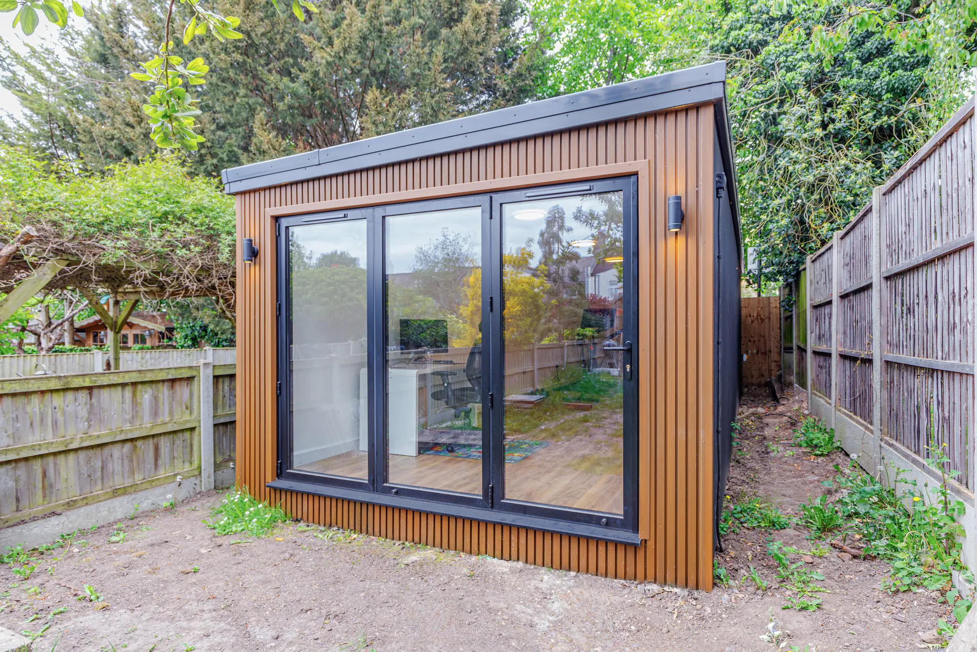 Closer view of a timber-clad garden studio with closed glazed doors