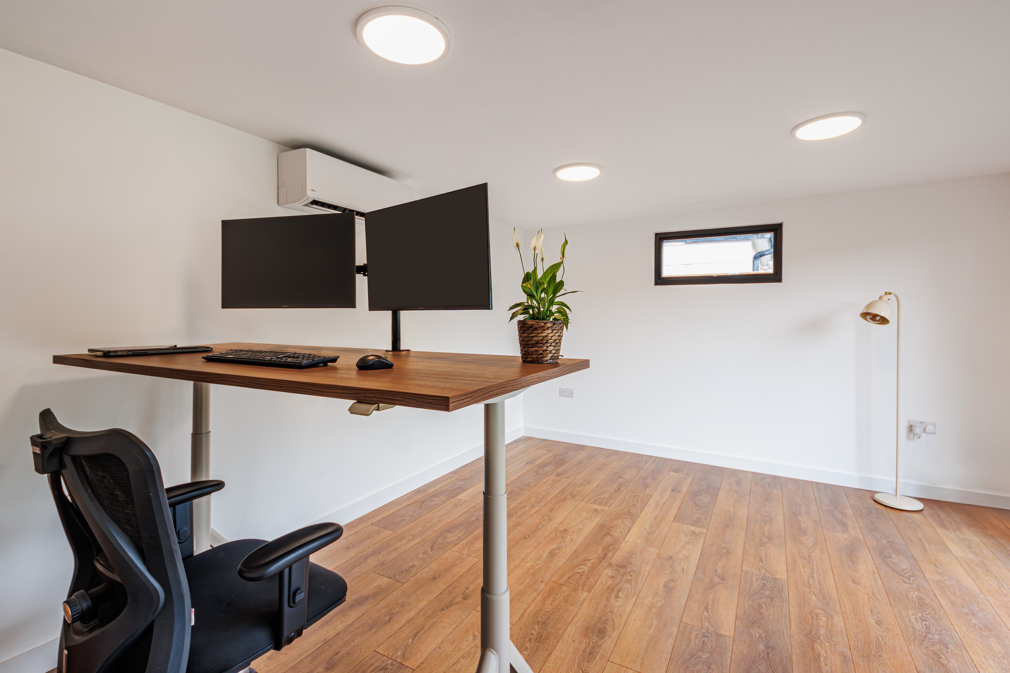 Garden office in Bedfordshire — interior fitted with a sit-stand desk, dual monitors and air conditioning