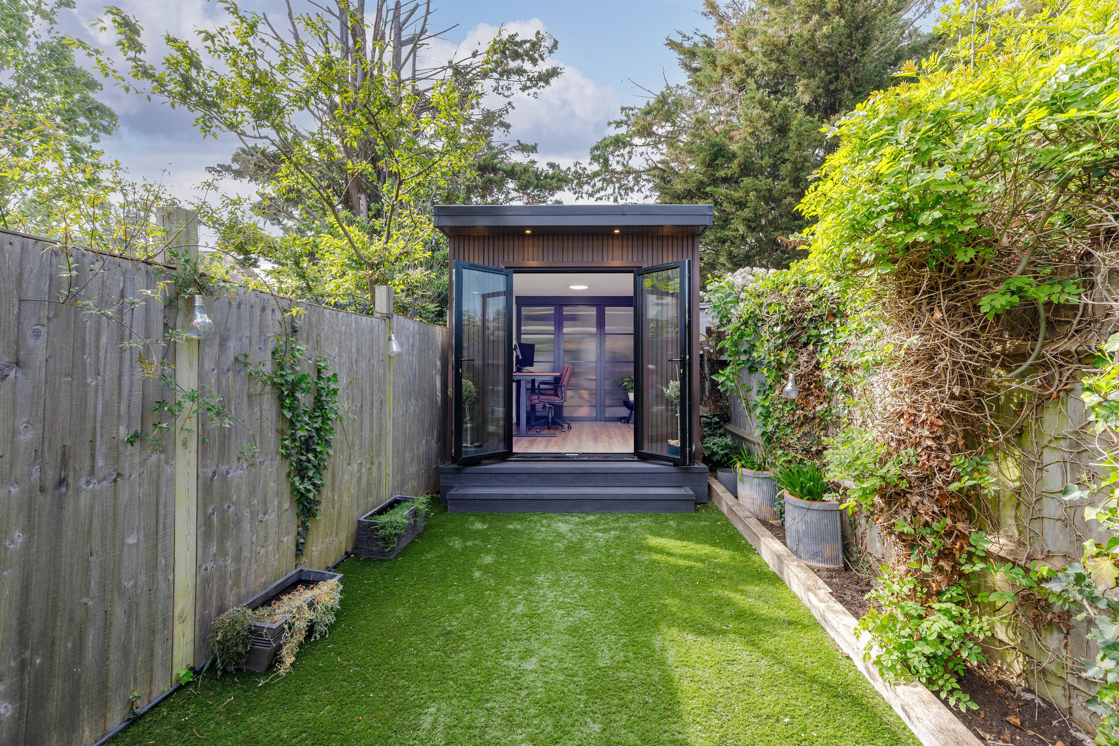 Garden office in Bedfordshire — timber-clad office with bifold doors at the end of a narrow garden